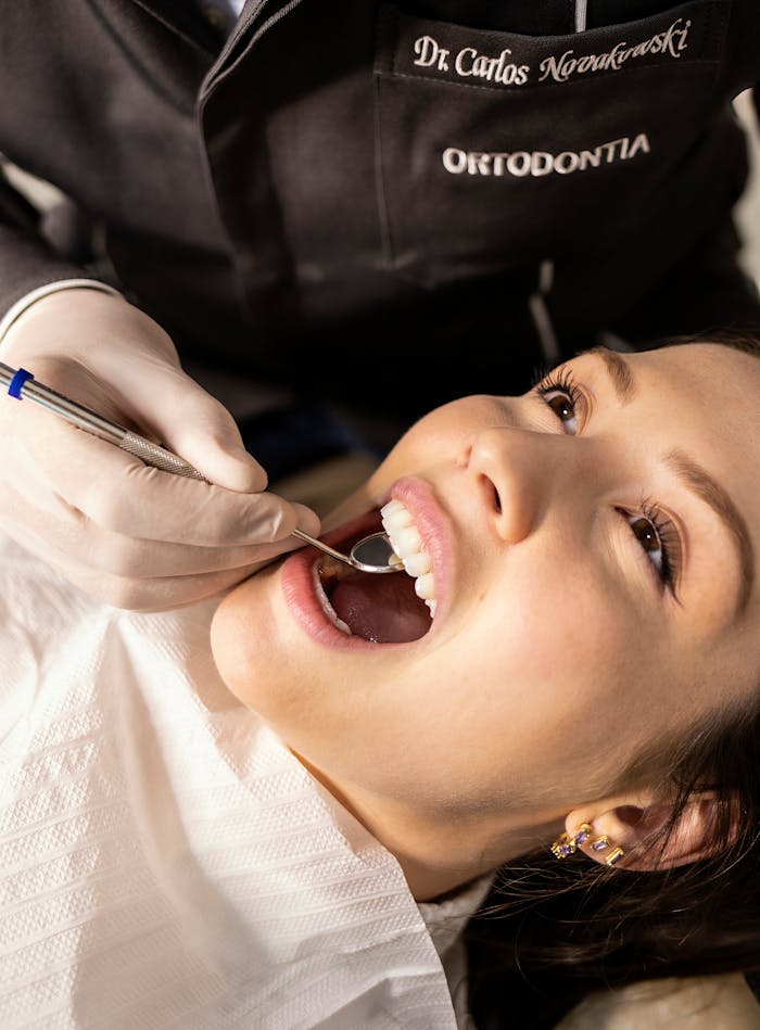 The Art of Drawing Readers In: Your attractive post title goes here Close-up portrait of a woman receiving a dental checkup in a clinic setting.