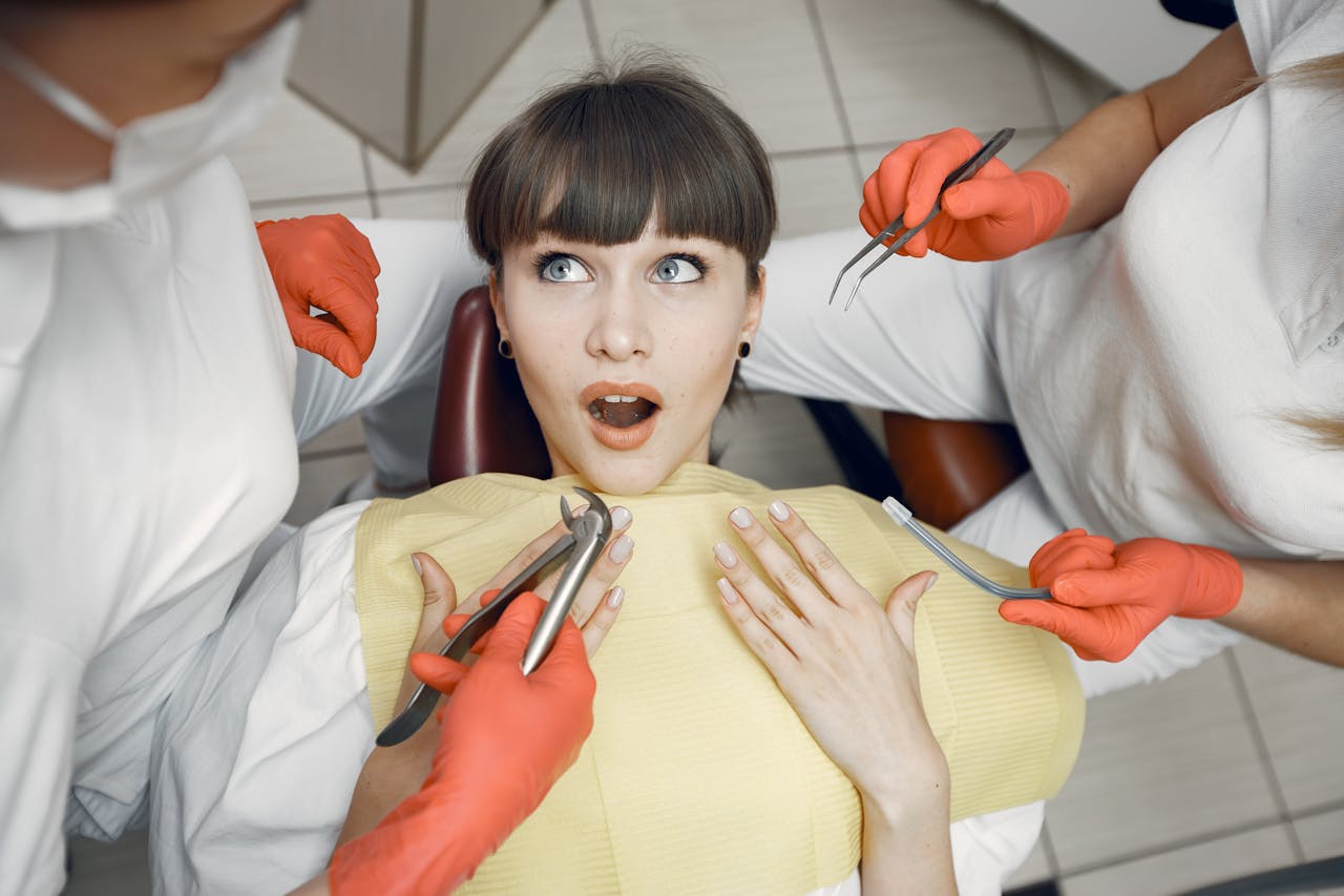 Mastering the First Impression: Your intriguing post title goes here A female patient looking surprised while being examined by dentists in a clinic.